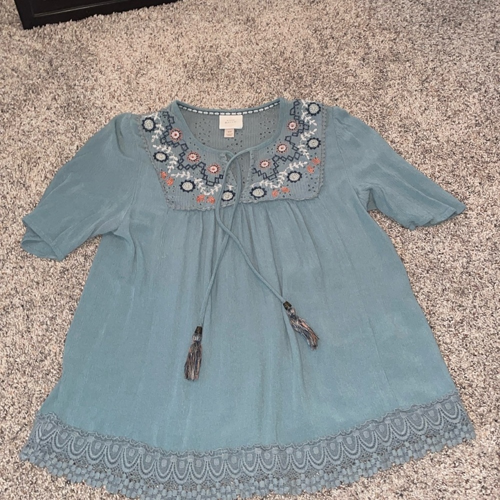 Blouse with tied tassels. Flower design on chest. Lace at bottom size XS.